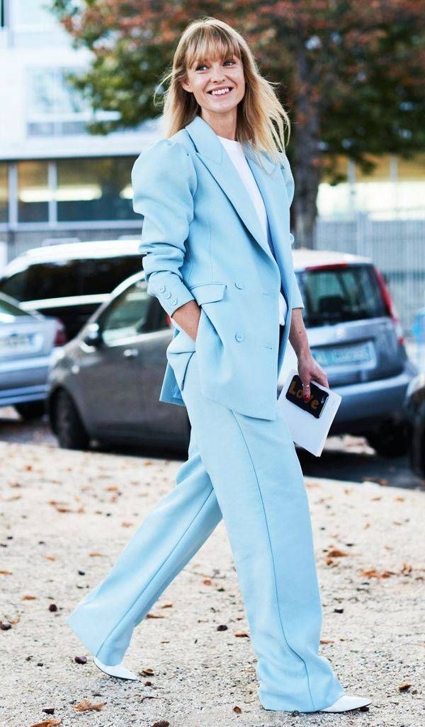 Woman wearing an icy blue blazer and matching wide-leg trousers, winter street style
