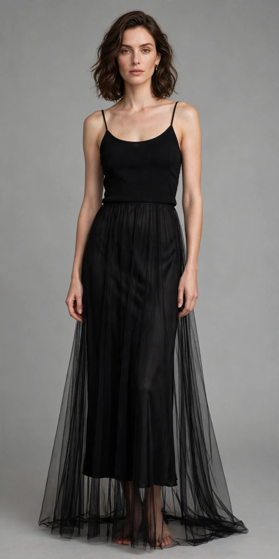 Woman in a sheer black maxi skirt layered over a matching opaque black slip, tasteful sheer runway trend outfit