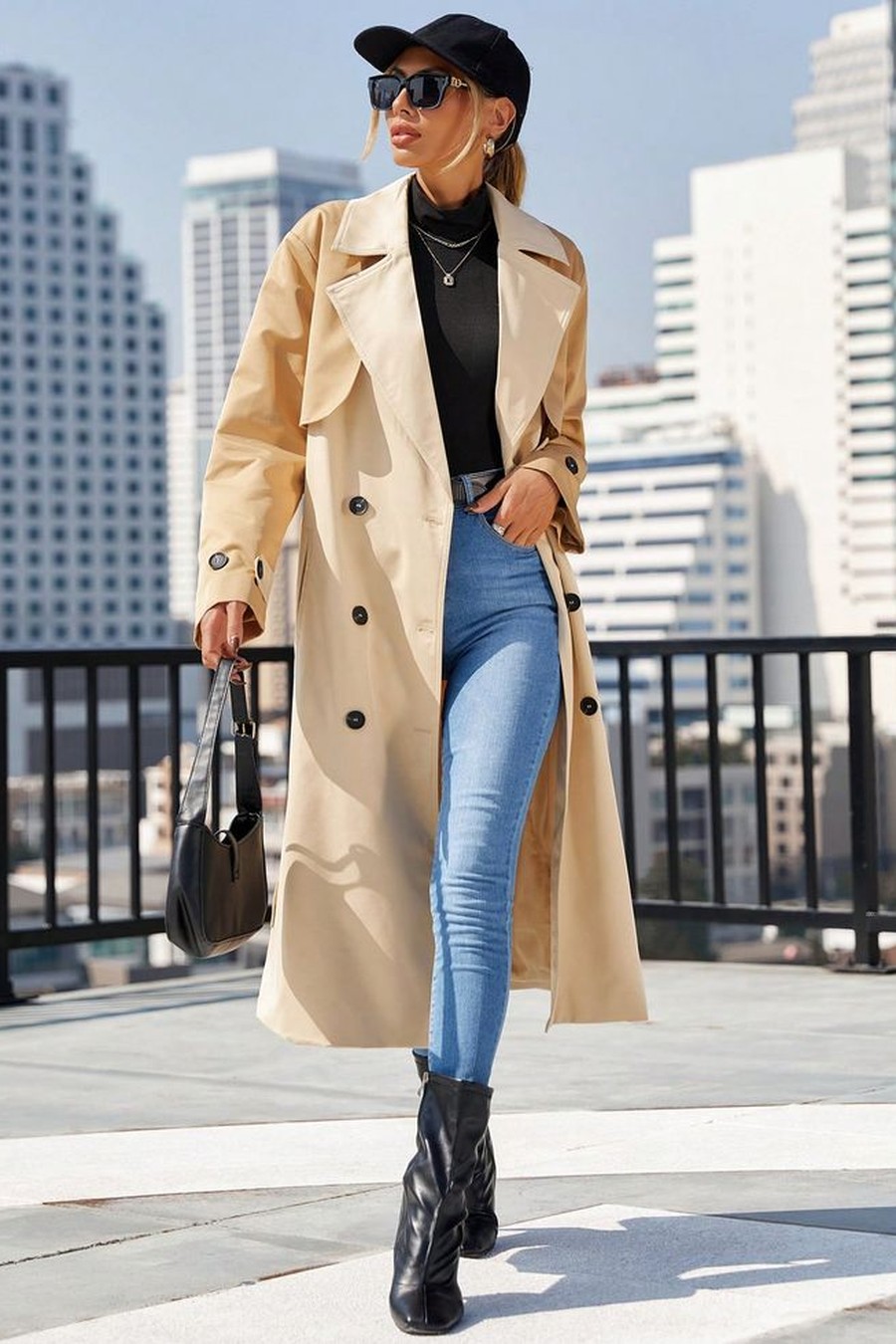 Beige trench coat with a black baseball cap, jeans and boots