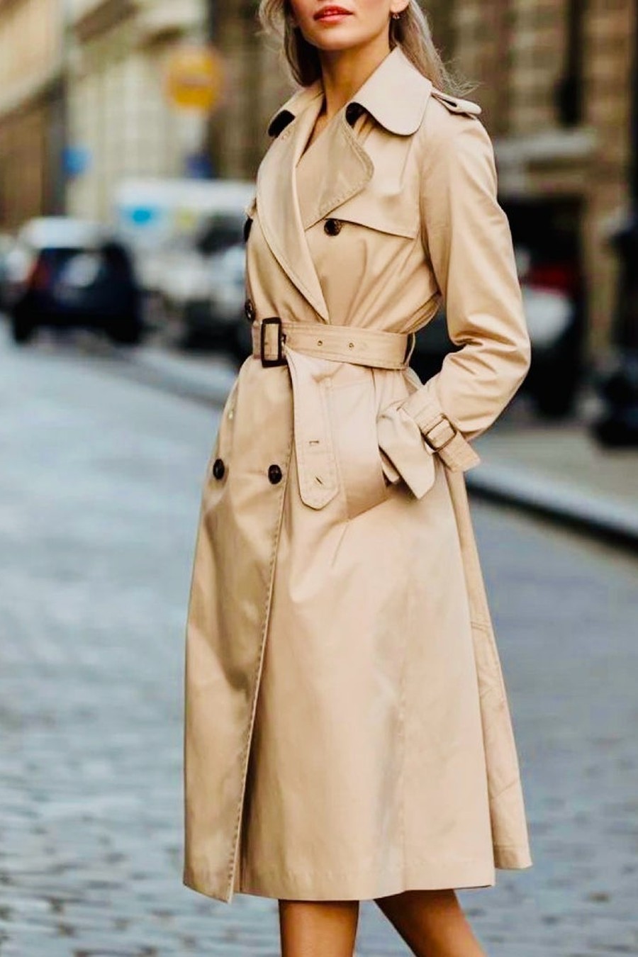 Close-up detail of a belted trench coat waist with horn buttons